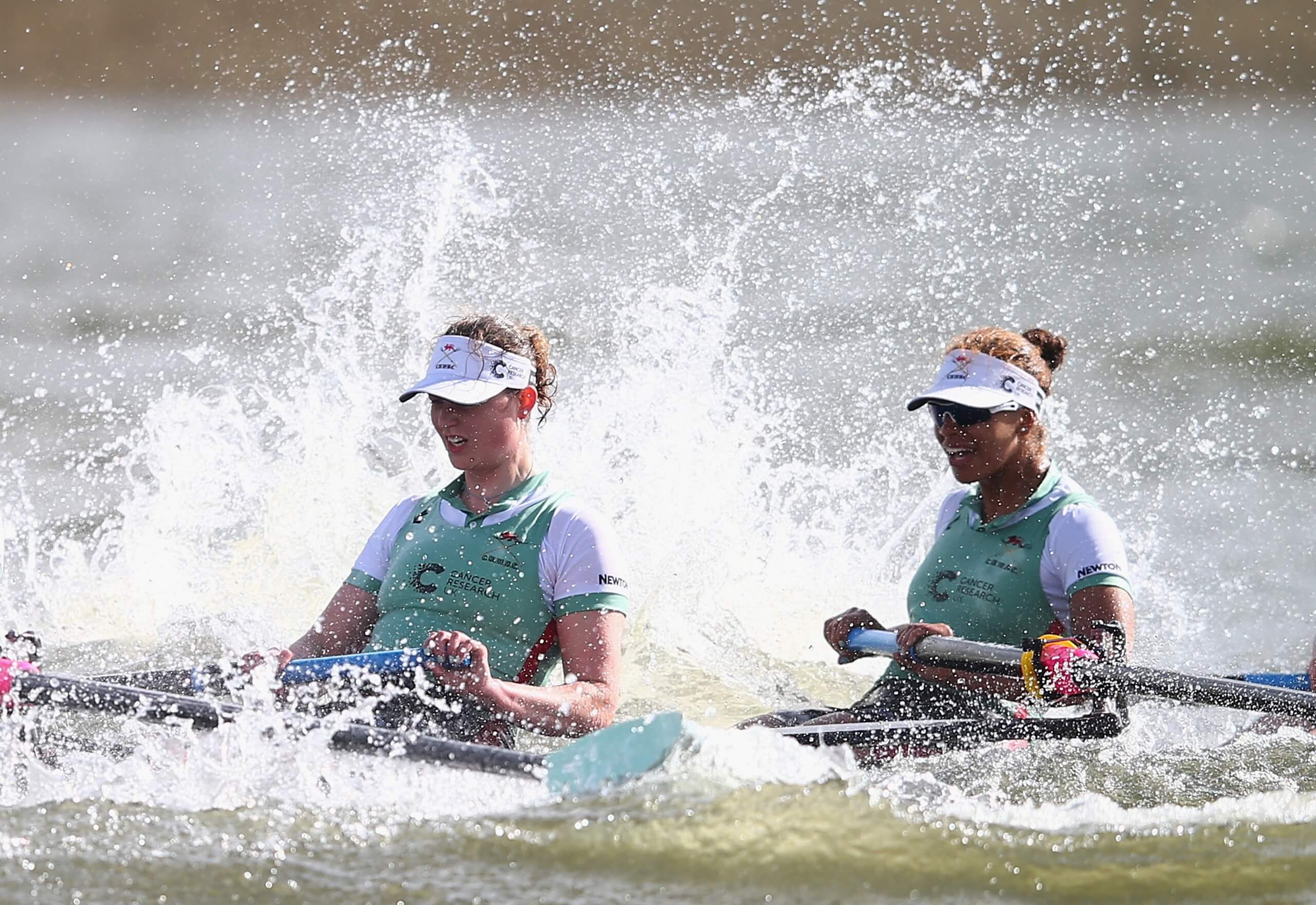 2 rowers with waves breaking over them